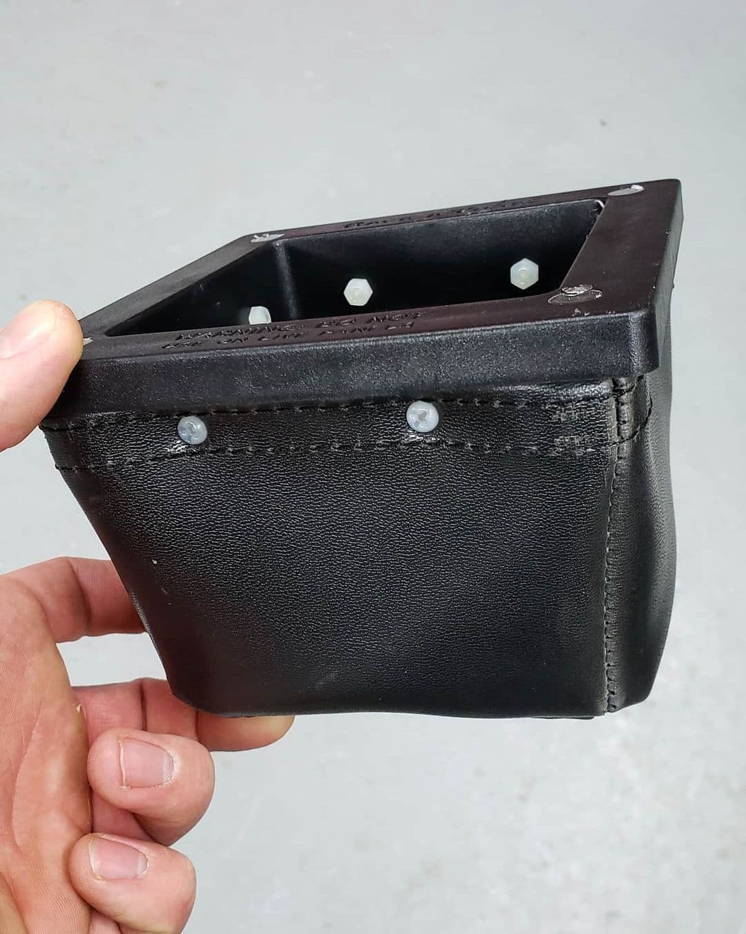 The Rack-A-Tiers Dirt Bag clinging to metal using its rare earth magnets.