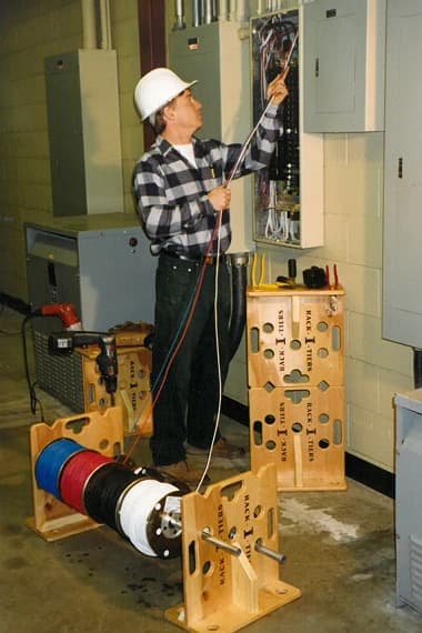 Ken holding an early Rack-A-Tiers wooden cable caddy prototype